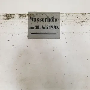 Dirt marks from recent flood run across sign showing height of 1897 flood in Dirt marks from recent flood run across sign showing height of 1897 flood in
