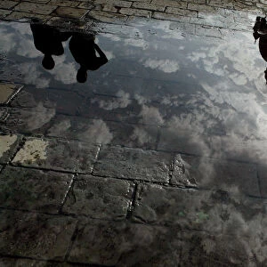 Domes of a hotel are reflected in a puddle of rain water in Mumbai