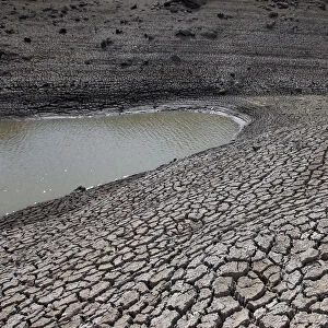 Dried mud is seen during a low-level period of water in Concepcion reservoir on the