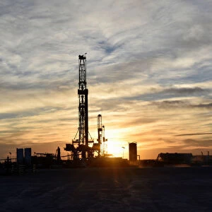Drilling rigs operate at sunset in Midland
