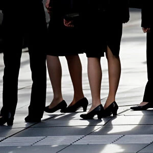 Female office workers wearing high heels, clothes and bags of the same colour are seen at
