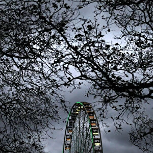 A ferris wheel is illuminated against the evening sky in Hyde Park in London, Britain