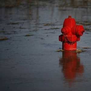 A fire hydrant in floodwaters that froze overnight is seen near a levee in Valley City