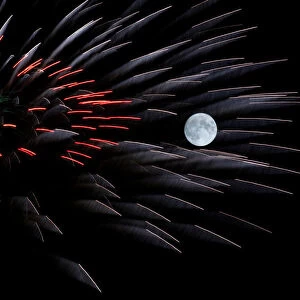 Fireworks explode in front of the full moon during celebrations marking the feast