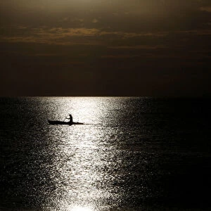 A fisherman casts his net before sunset in Baseco district, metro Manila