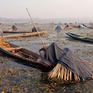 Fishermen cover their heads and part of their boats with blankets