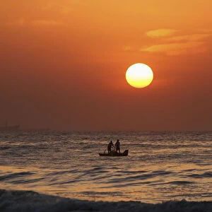 Fishermen pull their fishing net from the waters of Bay of Bengal during sunrise in
