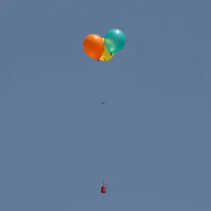 Flaming balloons are released by Palestinian demonstrators to the Israeli side during a