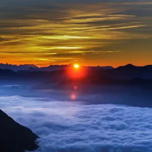 Fog covers the Inntal valley as the sunrise is seen from the Hundskopf mountain in Fog covers the Inntal valley as the sunrise is seen from the Hundskopf mountain in