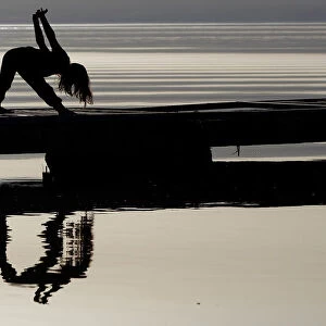 A girl practices yoga on the banks of Lake Ohrid in Ohrid
