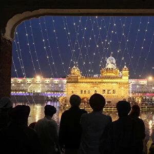 The Golden Temple is seen illuminated as Sikh devotees arrive on the eve of the 550th