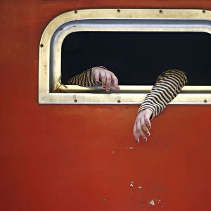The hands of a passenger on board a train are pictured at the train station in Jakarta