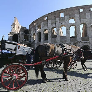 A horse-drawn carriage is seen in front of Romes ancient Colosseum downtown Rome