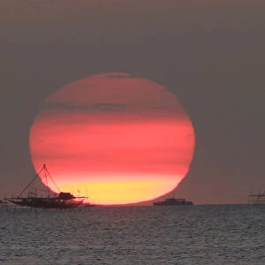 Houses on stilts are seen as the sun sets around the Manila bay in Manila