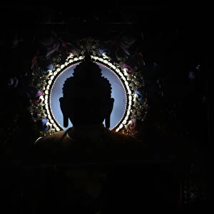 An idol of Buddha is silhouetted at the Tibetan Monastery in Lumbini