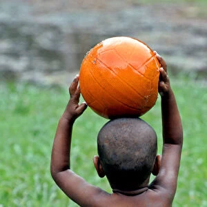 An Indian child plays with a basketball in a field in the eastern Indian city of Calcutta