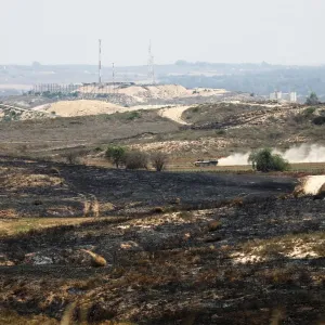 An Israeli armoured personnel carrier (APC) drives on the Israeli side of the border