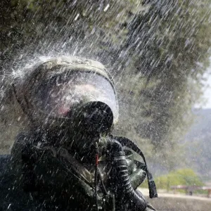 An Israeli soldier wearing a protective gear is sprayed with water during a drill