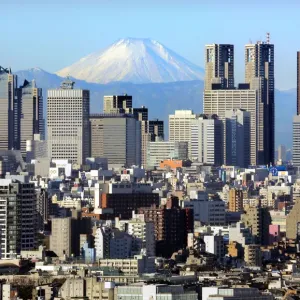 Japans Mt Fuji, covered with snow, is seen through Shinjuku skyscrapers in Tokyo