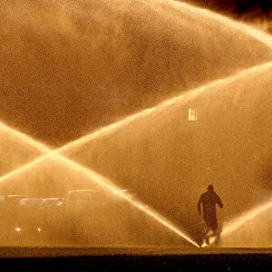 A jogger makes his way past sprinklers in Washington