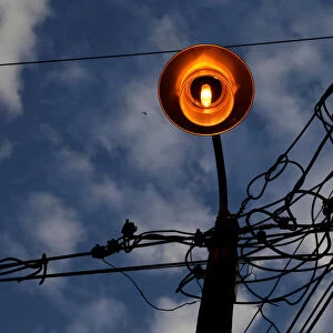 A lighting pole with electrical and telephone cables are seen in a street in Asuncion