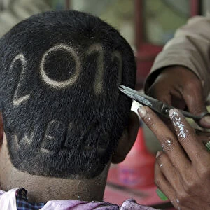 A man gets a haircut depicting 2011 to welcome the new year at a barbershop in the