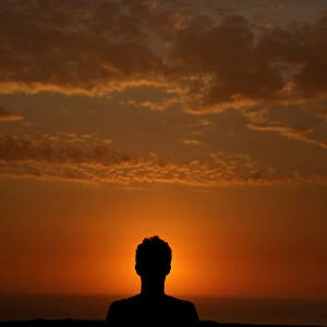 A man observes sunset in front of Limas Miraflores district in Peru