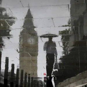 A man is reflected next to Big Ben on a wet pavement during a rainy day in central London A man is reflected next to Big Ben on a wet pavement during a rainy day in central London