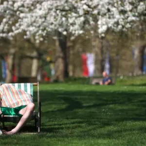 A man relaxes in the sunshine in St James Park in central London