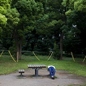 A man sleeps on bench in Yoyogi Park in Tokyo