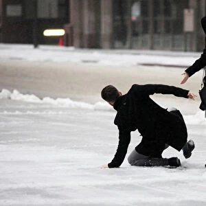 A man slips on ice covered sidewalk as freezing rain falls in Toronto