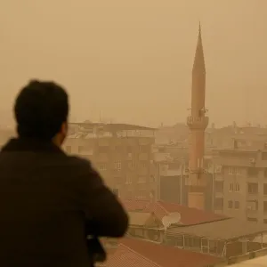 A man stands on top of a building during a dust storm in Diyarbakir A man stands on top of a building during a dust storm in Diyarbakir