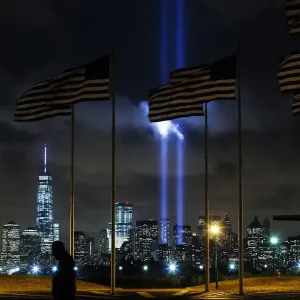 Man walks past as the Tribute in Light is illuminated on the skyline of lower Manhattan Man walks past as the Tribute in Light is illuminated on the skyline of lower Manhattan