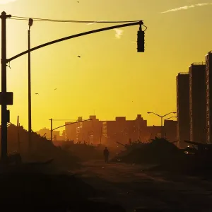 A man walks down Shore Front Parkway surrounded by debris pushed onto the streets by A man walks down Shore Front Parkway surrounded by debris pushed onto the streets by
