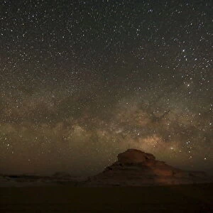 The Milky Way is seen in the night sky over rocks in the White Desert north of the