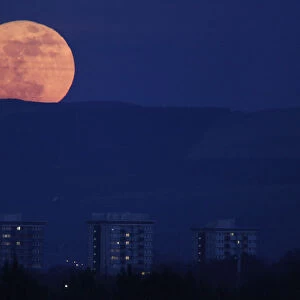 The moon rises over the horizon above the Peak District national park near Manchester