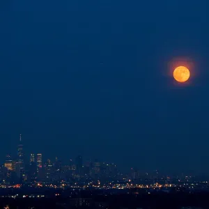 The full moon rises over the skyline of New York and One World Trade Center as seen The full moon rises over the skyline of New York and One World Trade Center as seen