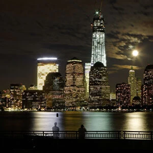 The moon rises behind the skyline of New Yorks Lower Manhattan and One World Trade
