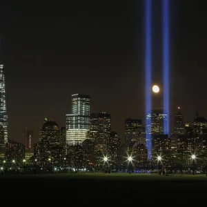 The moon rises between the Tribute in Light illuminated next to One World Trade The moon rises between the Tribute in Light illuminated next to One World Trade