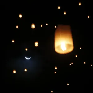 The moon is seen behind lanterns released by survivors, local residents and visitors The moon is seen behind lanterns released by survivors, local residents and visitors