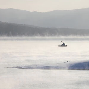 A motor boat sails through a frosty fog across the Yenisei River outside Krasnoyarsk
