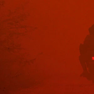 A motorcyclist passes through haze near burnt peat land in Rokan Hilir
