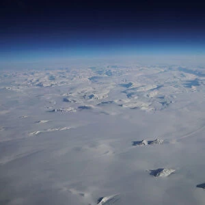 Mountains stick up through a massive ice sheet covering Greenland near the eastern coast