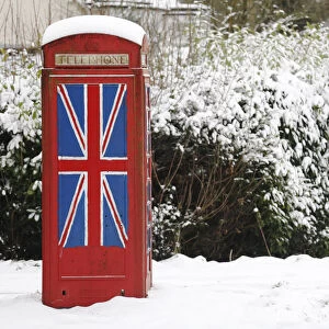 An old telephone box painted with the Union Flag stands out in the snow at Staplefield