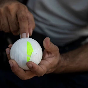A Pakistani man living in Greece wraps a tennis ball in electrical tape before a