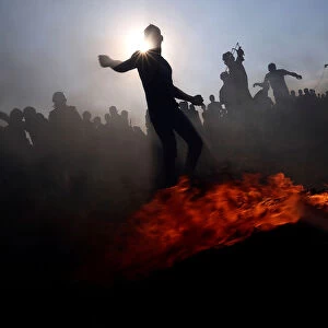 Palestinian demonstrators hurl stones at Israeli troops during a protest at the border