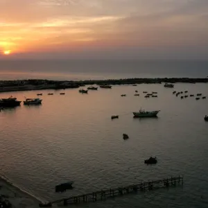 Palestinian fishermen are seen fishing during the last sunset of the year in Gaza