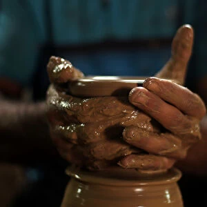 Palestinian worker makes clay pots at a pottery workshop in Gaza City
