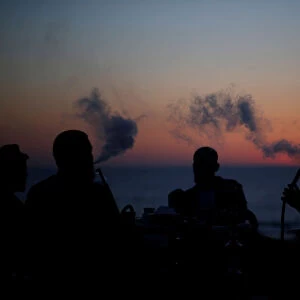 Palestinians smoke shisha on the beach in Gaza City