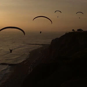 Paragliders fly in front of Limas Miraflores district